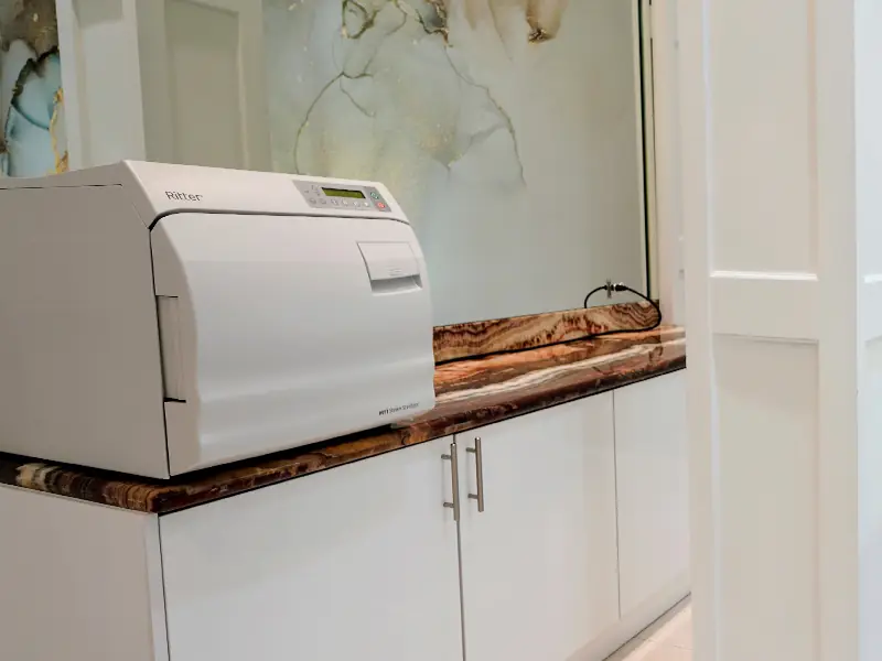 The autoclave sterilizer on the counter, run between every guest